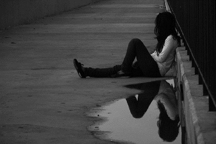 Cô gái buồn ngồi trên cầu
